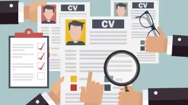 Kilka dłoni trzymających CV, listę kontrolną i lupę.