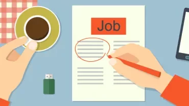 Person reviewing a job advertisement with coffee, USB drive, and smartphone.