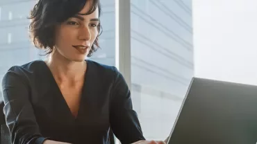 Kobieta pracująca na laptopie w nowoczesnym biurze.