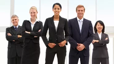 A diverse group of five business professionals smiling.