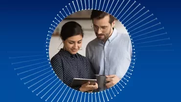 Dwie osoby omawiają coś, patrząc na tablet.