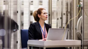 Woman sitting alone in a room with a laptop