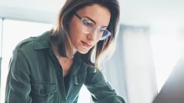 Woman looking down at her laptop, focused