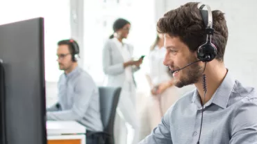 Man sitting with headphones in front of his computer