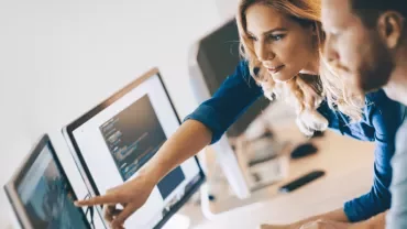 Woman and man sitting in front of computer