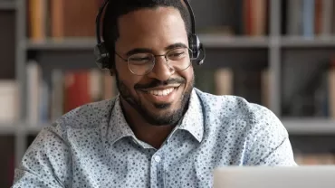 Man smiling looking at his laptop