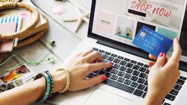 Woman shopping online using a credit card and laptop.