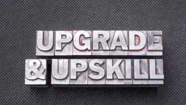 Metal letter blocks spelling 'Upgrade & Upskill'