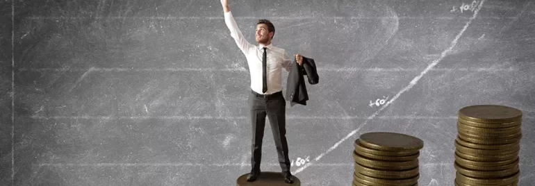 Man standing on coins, chalkboard graph in background