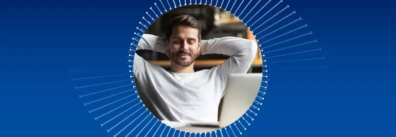 Man relaxing with hands behind head in front of a laptop.