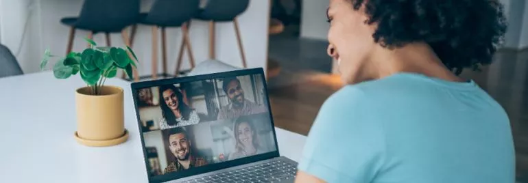 Person smiling during a video call on a laptop.