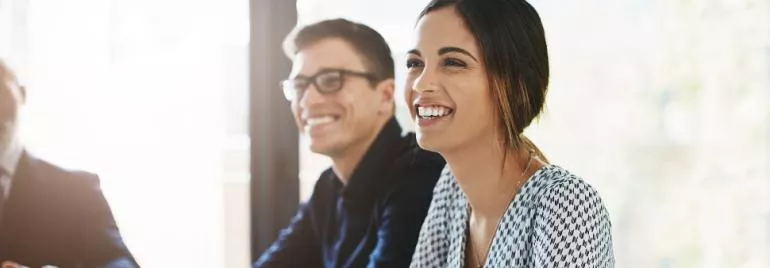 Two people smiling during a meeting.