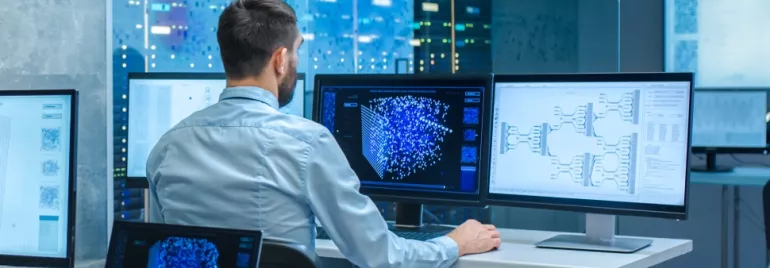 Man analyzing data on computer screens in a server room.