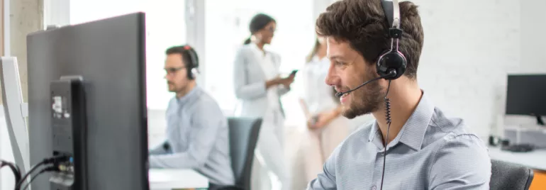 Man sitting with headphones in front of his computer