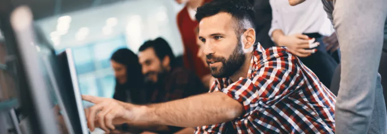 Man pointing at something on laptop screen