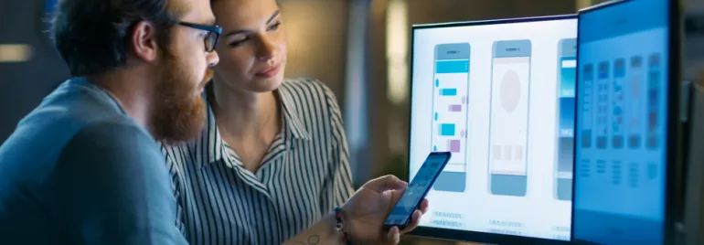 One man and one woman looking at graphics on a computer