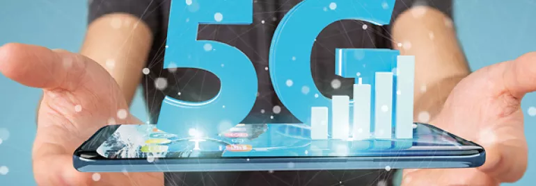 Person holding a smartphone with a 5G hologram above it.