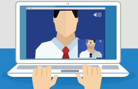 Laptop screen showing video call with two people in a meeting.